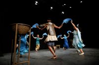 Six actors in classical costumes dancing with scarves