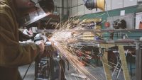 Student grinding metal in workshop