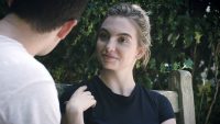 Close up of female student looking at fellow student on bench outside