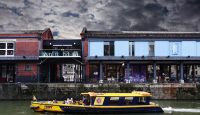 Photo of Bristol harbourside with a yellow ferry on the water