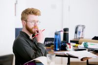 Writer with a pencil in their hand thinking