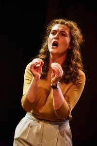 Female actor stood on stage with arms in front