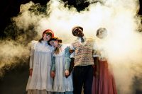 Four actors all with their eyes closed, surrounded by smoke