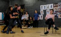 Students holding each other and one sat in a chair and three stood in background