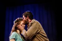 Two actors facing each other, eyes closed, one kissing the others forehead