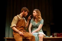 Two actors sat on stage looking at each other, one pointing his finger