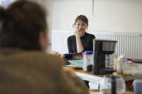 Student sat at table smiling