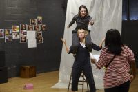 Actors in rehearsals, one sat on shoulders of another