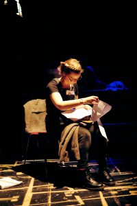 Female student sat backstage looking at papers