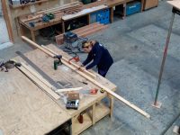 Student measuring wood prior to cutting in workshop