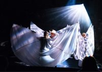 Actors on stage dressed as angels and one dressed as a cowboy