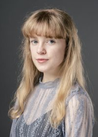 Headshot of woman with long blonde hair and a full fringe