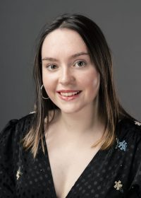 Headshot of girl smiling at camera with shoulder length brown hair