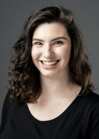 Headshot of smiling woman with dark brown curly hair