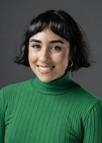 Headshot of smiling woman with short black hair in a green top