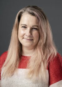 headshot of woman with long blonde hair in a red and white top