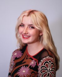 Headshot of woman with blonde hair smiling at camera