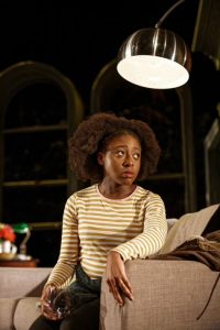 Actor sat on sofa looking pensive, holding glass