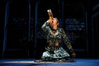 Actor knelt on floor drinking from bottle