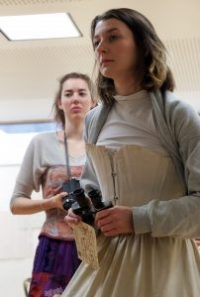 Actors in rehearsals, one in Edwardian costume