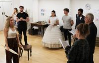 Actors in rehearsal, one wearing Edwardian costume