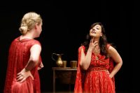 Two actors on stage in red robes