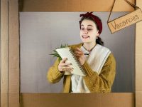 Female student in performance holding a plant and making notes on a pad