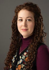 Headshot of female with long brown curly hair