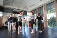 A group of actors in a studio environment working in pairs and clapping their hands