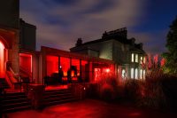 The School's main site Downside road is lit up at night with red lighting